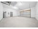 Spacious garage featuring white walls and ceiling, light grey door, and concrete flooring at 4312 Sw 172Nd Place Rd, Ocala, FL 34473