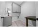 Laundry room with sink, grey cabinets, folding table, black fixtures, and modern vinyl flooring at 4312 Sw 172Nd Place Rd, Ocala, FL 34473
