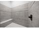 Modern walk-in shower featuring gray tiles, black fixtures, a shower bench, and mosaic tile floor at 4312 Sw 172Nd Place Rd, Ocala, FL 34473