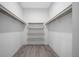 Walk-in closet offers ample storage with a modern wood shelving system and vinyl floors at 4312 Sw 172Nd Place Rd, Ocala, FL 34473
