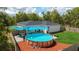 Aerial view of a backyard with a round above-ground pool, deck and well-manicured lawn at 46 Fisher Lane Ter, Ocklawaha, FL 32179