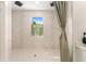 Spacious tiled shower with double shower heads, decorative trim, and a window at 46 Fisher Lane Ter, Ocklawaha, FL 32179