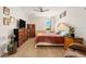 Bright bedroom featuring a cozy armchair, a crib, and a comfortable queen size bed at 46 Fisher Lane Ter, Ocklawaha, FL 32179