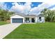 Charming single-story home featuring a well-manicured lawn and a two-car garage at 46 Fisher Lane Ter, Ocklawaha, FL 32179