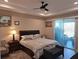 Serene main bedroom featuring a tray ceiling, a ceiling fan, and sliding glass doors for natural light and fresh air at 4770 Sw 114Th St, Ocala, FL 34476