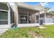 Backyard featuring the rear exterior with screened-in patios, lush grass, and an AC unit at 4927 Sw 45Th Cir, Ocala, FL 34474