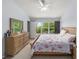 Bright bedroom features a large window with green outdoor views, creating a serene atmosphere at 4927 Sw 45Th Cir, Ocala, FL 34474
