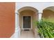 Covered townhome entrance framed by decorative columns, lush landscaping, and an inviting door at 4927 Sw 45Th Cir, Ocala, FL 34474
