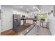 Open kitchen boasts white cabinets, granite counters, stainless steel appliances, and seamlessly adjoins the living area at 4927 Sw 45Th Cir, Ocala, FL 34474