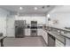 Modern kitchen featuring stainless steel appliances, granite counters, and crisp white cabinetry for a clean aesthetic at 4927 Sw 45Th Cir, Ocala, FL 34474