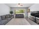 Bright living room featuring neutral colors, tile flooring, and sliding door access to the screened lanai at 4927 Sw 45Th Cir, Ocala, FL 34474
