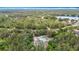 Aerial view of a green home nestled among trees with space for a fire pit and close to a scenic lake at 505 Fisher Rd, Ocklawaha, FL 32179