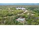 Expansive aerial view showcases a charming home with lake access amidst lush greenery and a winding road at 505 Fisher Rd, Ocklawaha, FL 32179