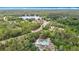 Expansive aerial view showcases a charming home with lake access amidst lush greenery and a winding road at 505 Fisher Rd, Ocklawaha, FL 32179