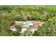 Aerial view of a charming home with a green metal roof, surrounded by lush trees at 505 Fisher Rd, Ocklawaha, FL 32179