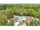 Aerial view of the property, featuring a home with a green metal roof and a wooded lot at 505 Fisher Rd, Ocklawaha, FL 32179