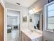 Bright bathroom leading to a bedroom, featuring a wide mirror and white marble vanity at 505 Fisher Rd, Ocklawaha, FL 32179