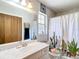 Bathroom featuring a wide mirror, white vanity, patterned shower curtain and toilet seat cover at 505 Fisher Rd, Ocklawaha, FL 32179