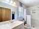 Bathroom with a white marble vanity, mirror, window and shower stall at 505 Fisher Rd, Ocklawaha, FL 32179