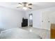 Neutral toned bedroom featuring tile flooring, ceiling fan, and a doorway leading to the bathroom at 505 Fisher Rd, Ocklawaha, FL 32179