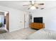 Bedroom with ensuite, featuring tile flooring, window, ceiling fan, dresser and a neatly made bed at 505 Fisher Rd, Ocklawaha, FL 32179