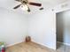 Clean bedroom features laminate floors, a ceiling fan, and neutral walls next to a bathroom entrance at 505 Fisher Rd, Ocklawaha, FL 32179