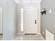 A simple entryway with tile flooring features a white front door and a small shelf at 505 Fisher Rd, Ocklawaha, FL 32179