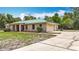 This single-story home has a light-colored metal roof and an attached two car garage with a concrete driveway at 505 Fisher Rd, Ocklawaha, FL 32179