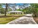 A concrete driveway leads up to this house featuring a metal roof and an attached two car garage at 505 Fisher Rd, Ocklawaha, FL 32179