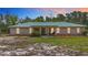 This single-story home has a light-colored metal roof and a simple, landscaped front yard at 505 Fisher Rd, Ocklawaha, FL 32179