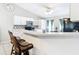 Bright kitchen featuring breakfast bar, stainless microwave, and tiled backsplash at 505 Fisher Rd, Ocklawaha, FL 32179