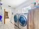 Convenient laundry room equipped with stainless steel washer and dryer, storage cabinets and outside access at 505 Fisher Rd, Ocklawaha, FL 32179