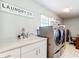 Well-lit laundry room features modern appliances, a sink, and ample storage, perfect for efficient chores at 505 Fisher Rd, Ocklawaha, FL 32179