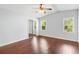 Cozy bedroom featuring hardwood floors, a ceiling fan, and closet with sliding mirrored doors at 518 Saint Andrews Blvd, Lady Lake, FL 32159