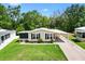 Single-story home with a well-manicured lawn, carport, and lovely landscaping at 518 Saint Andrews Blvd, Lady Lake, FL 32159