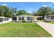 Charming single-story home featuring a lush lawn, carport, and screened entrance at 518 Saint Andrews Blvd, Lady Lake, FL 32159