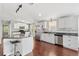 Modern kitchen with stainless steel appliances, a breakfast bar, hardwood floors, and white cabinets at 518 Saint Andrews Blvd, Lady Lake, FL 32159