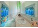 Bright bathroom featuring a white sink and a colorful shower curtain with an ocean theme at 5340 Nw 26Th Ln, Ocala, FL 34482