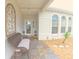 Inviting front porch with tiled flooring, bench seating, and arched windows providing ample light at 5340 Nw 26Th Ln, Ocala, FL 34482