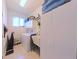 Functional laundry room includes a washer, dryer, utility sink, storage cabinet, and bright window at 5340 Nw 26Th Ln, Ocala, FL 34482
