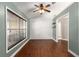 Well-lit room with wood floors, a modern ceiling fan, and a large window offering plenty of natural light at 5437 Se 34Th St, Ocala, FL 34480