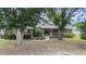 Inviting front of house with large trees, well-maintained lawn, and cozy porch, creating a warm welcome at 5437 Se 34Th St, Ocala, FL 34480