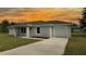 Single-story home featuring a one-car garage, concrete driveway, manicured lawn, and vibrant sunset backdrop at 5635 Nw 2Nd St, Ocala, FL 34482