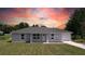 Charming single-story home with a well-maintained lawn and neutral paint, illuminated by a vibrant sunset backdrop at 5635 Nw 2Nd St, Ocala, FL 34482