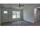 Bright living room with hardwood floors, a ceiling fan, and a large window showcasing the front yard at 5635 Nw 2Nd St, Ocala, FL 34482