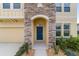 Close up of a home's front entrance with a stone archway and a blue front door at 5653 Sw 50Th Ter, Ocala, FL 34474