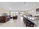 Open-concept living room and kitchen with tile floors, granite counters, and modern stainless appliances at 5653 Sw 50Th Ter, Ocala, FL 34474