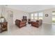 Bright living room featuring neutral walls, tile flooring, and comfortable leather seating at 5653 Sw 50Th Ter, Ocala, FL 34474