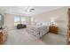 Spacious main bedroom with neutral walls, carpet, tray ceiling, ceiling fan, and large windows at 5653 Sw 50Th Ter, Ocala, FL 34474