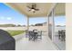 Covered patio with fan, outdoor dining set, and view of the fenced backyard at 5653 Sw 50Th Ter, Ocala, FL 34474